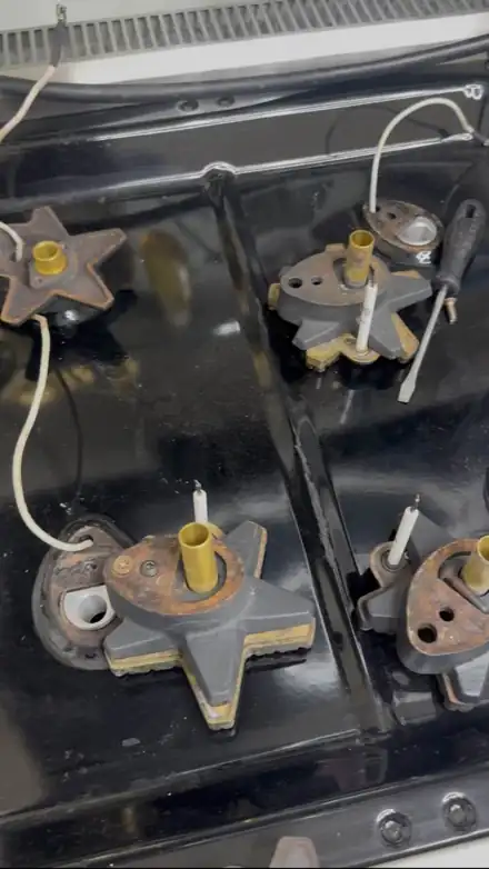 Gas range burner bases and spark igniters with the grates removed